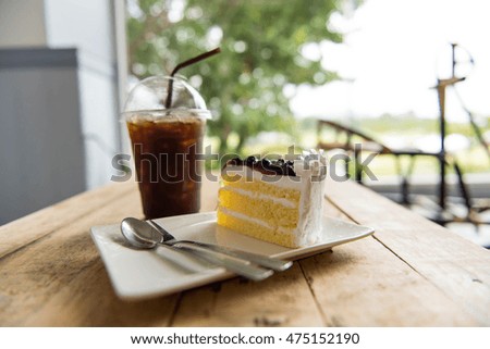 Ice coffee and blueberry cake on wood table,american Coffee,Americano,black coffee,