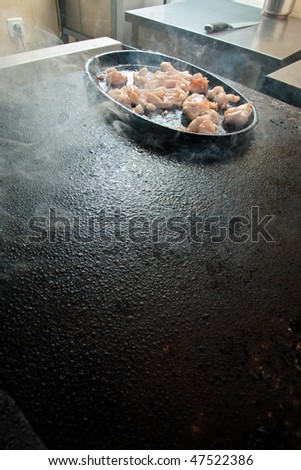 Chicken are fried on stove in commercial kitchen