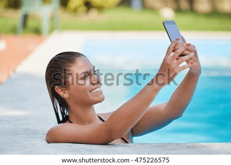 young woman taking a selfie on swimming pool