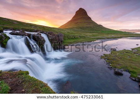 Amazing sunset the top of Kirkjufellsfoss waterfall with Kirkjufell mountain in the background on the north coast of Iceland's Snaefellsnes peninsula taken white a long shutter speed.
