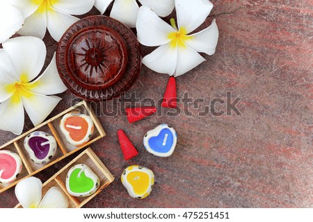 spa concept, aromatherapy candle with fresh frangipani flower on old brown grunge table background with space for text. over light