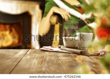 xmas time photo of wooden table with milk and fireplace 