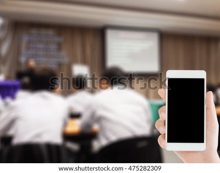 woman use mobile phone and blurred image of people in classroom