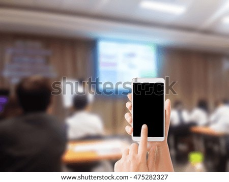 woman use mobile phone and blurred image of people in classroom