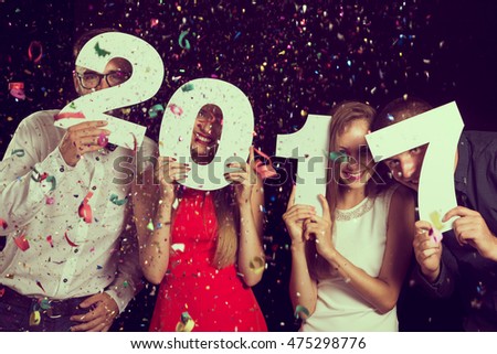 Two beautiful young couples having fun at New Year's Eve Party, holding cardboard numbers 2017 Royalty-Free Stock Photo #475298776