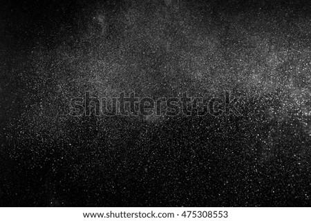 Freeze motion of white particles on black background. Powder explosion. Abstract dust overlay texture. 