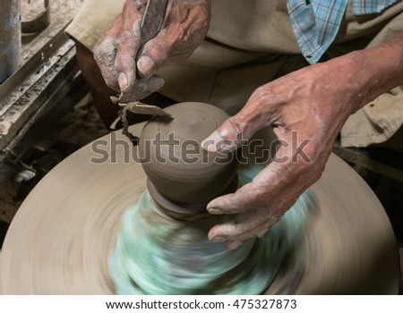 Hands working on pottery wheel.
