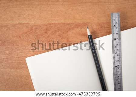 Top view open notebook white pages with pencil and ruler on wood texture desk background