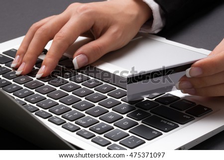 Office woman is typing on the laptop and holding the credit card
