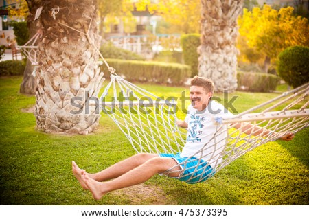 The boy sits on the hammock Royalty-Free Stock Photo #475373395