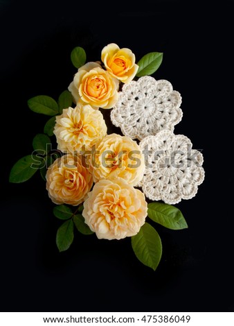 Beautiful English rose flower with crochet lace on black background          