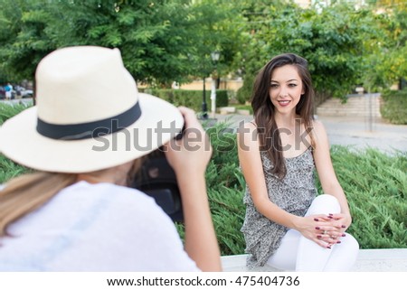 Two friends taking pictures in the park