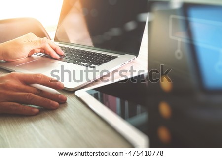 Website designer working digital tablet and computer laptop with design diagram on wooden desk and compact server
