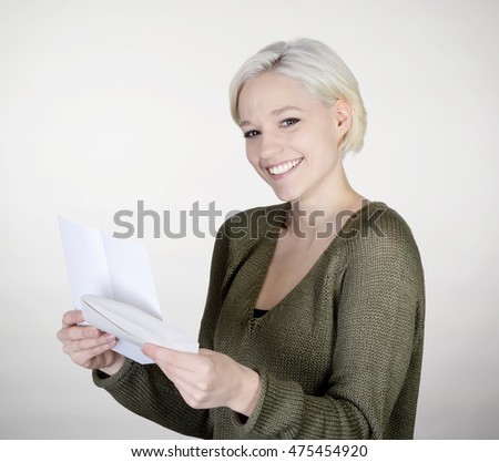 happy young woman reading letter, gray background