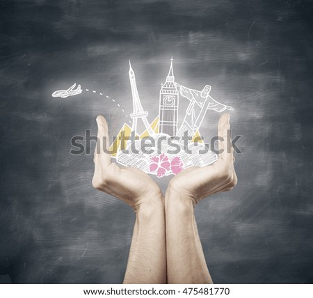 Hands holding traveling sketch on chalkboard background