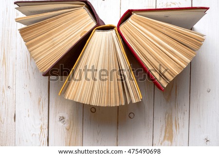 Top view of colorful hardback books in a circle. Open book, fanned pages isolated on white background, free copy space. Back to school copy space. Education background.
