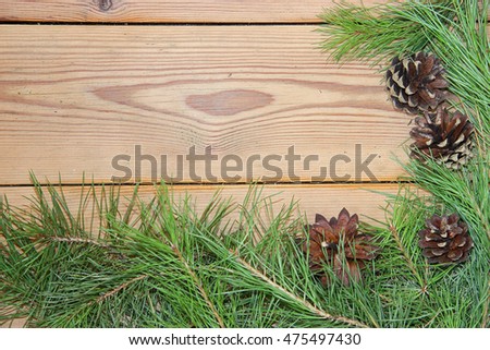 Christmas and New Year decoration composition on wooden background. Top view of  boards lined made of fir branches, needles and cones with place for your text