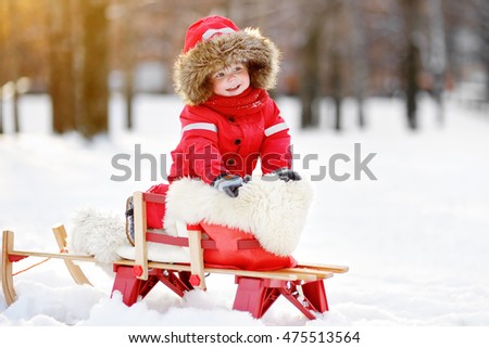 Portrait of beautiful toddler boy having fun in winter
