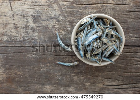 Dried Anchovies on the wooden background,Top view,Free space for text