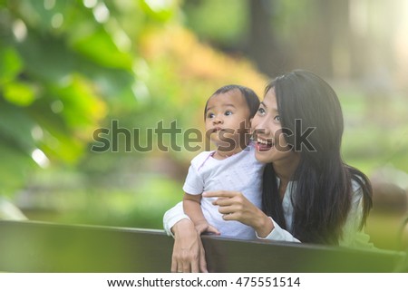 portrait of Beauty Mother and her Child playing in Park together