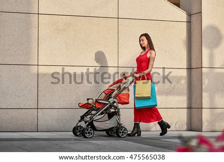 Fashionable modern mother on a city street summer