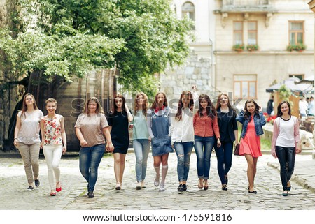 Group of many happy women walking having fun on background of old european city street, celebrating friendship concept, moments of happiness