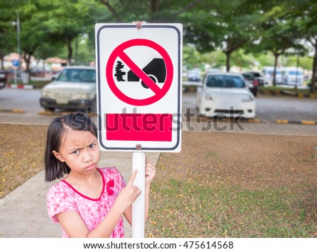 Asian kids is edgy and pointing at idle reduction sign, Education concept