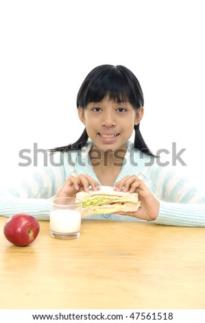 Girl eating healthy sandwiches with apple and glass of milk