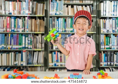 Asian Boy playing with plastic blocks in library room school