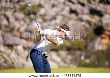 Close up image of a male golfer playing a shot on the fairway on a golf course in south africa.