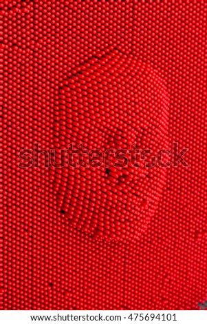 Face pressed to red pin art board