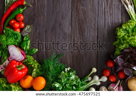 Frame of fresh organic vegetables on wood background. Healthy natural food on rustic wooden table with copy space. Onion, lettuce, carrot, garlic, zucchini and other cooking ingredients top view