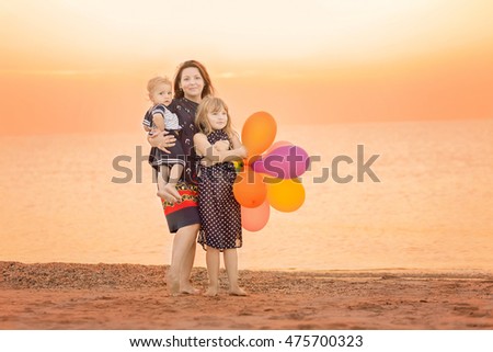 young family standing in an embrace on the beach. Toned colored image.