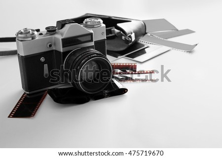 Vintage photo camera with photos on white table