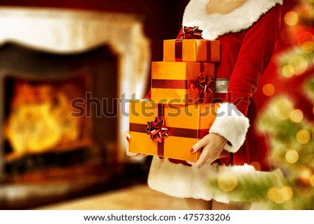 xmas gifts in hands and home interior with fireplace 