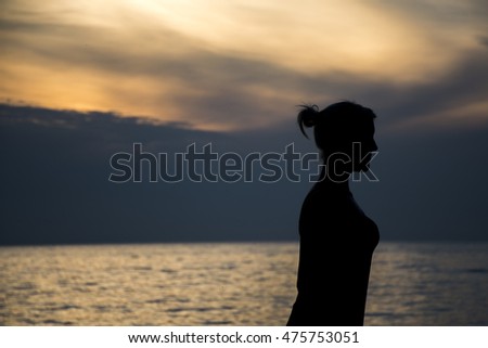Photo (no Illustration) of a girl at the beach during sunset
