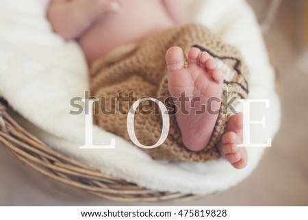 Close up picture of new born baby feet in knitted plaid. Little fingers. Newborn baby's legs. A closeup to babies feet