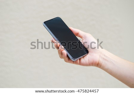 Close up hand holding black phone.
