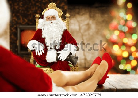 santa claus in home and fireplace with xmas tree background 