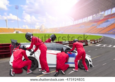  Pit stop with team maintaining technical service for a racing car during competition