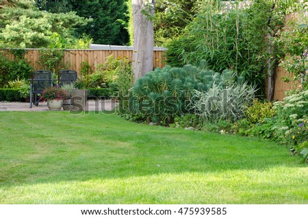 Garden with patio area, lawn and flowerbeds.