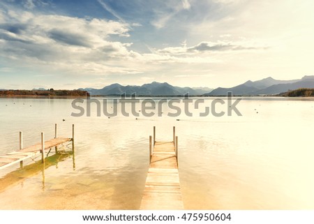 jetty on lake chiemsee with mountains in background