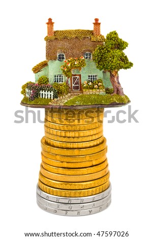 House and stack of coins isolated on white background