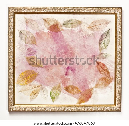 Photo of a frame with an abstract pink painting, with skeleton leaves scattered around it; the concept of delicate nature, with copyspace