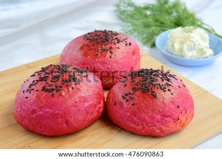 Beetroot bread bun with black sesame seeds served with cream cheese dill dip