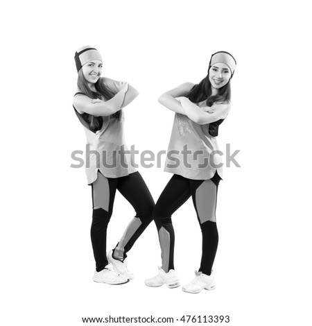 Two young professional cheerleaders posing at studio. Isolated over white. Black and white photography