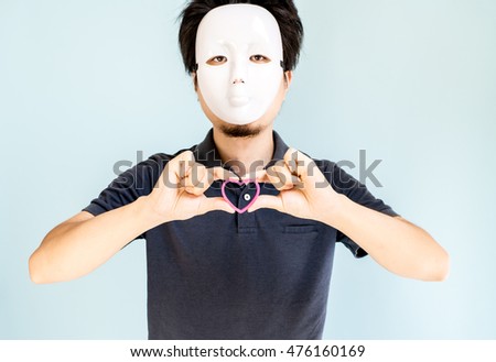 Man wearing mask holding heart mark