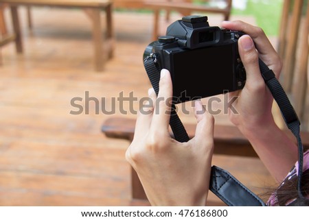 Woman viewing photos from a camera .camera with empty black screen. 