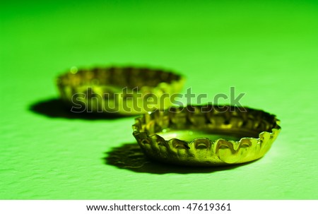 two beer caps on green background