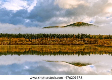 Lake in autumn cloudscape mountain in the background